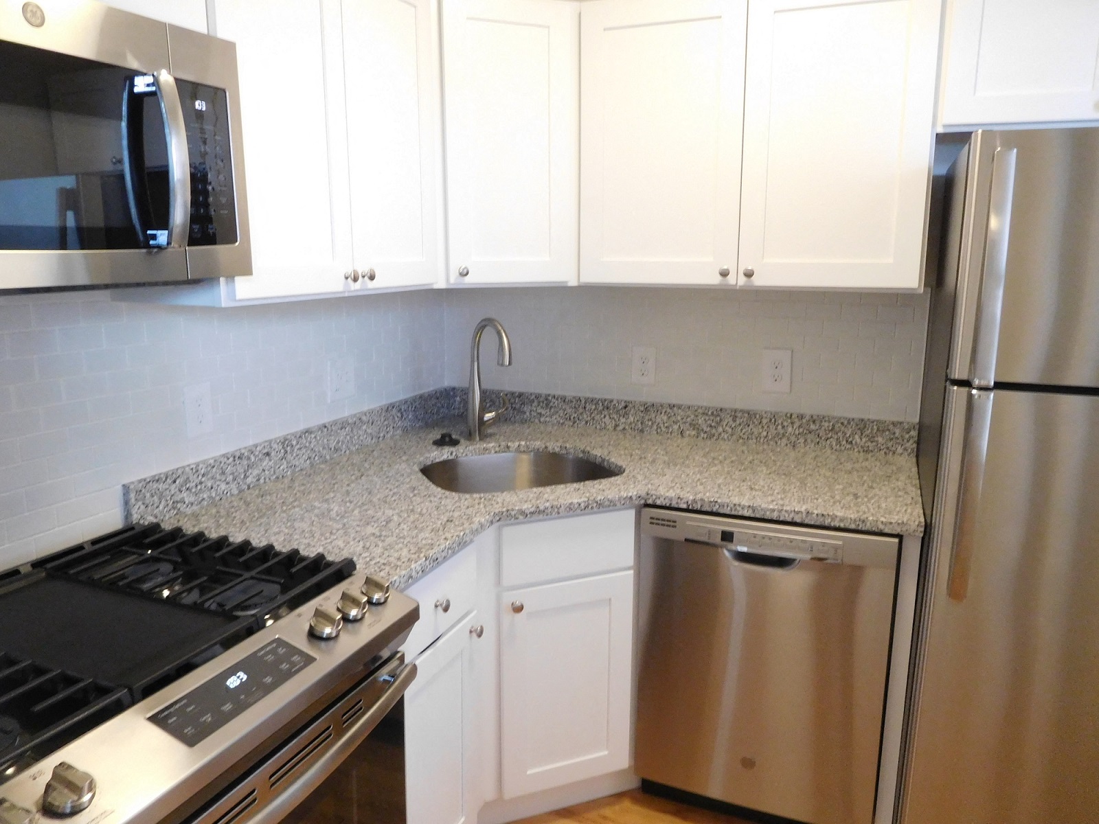 a kitchen with granite counter tops and stainless steel appliances